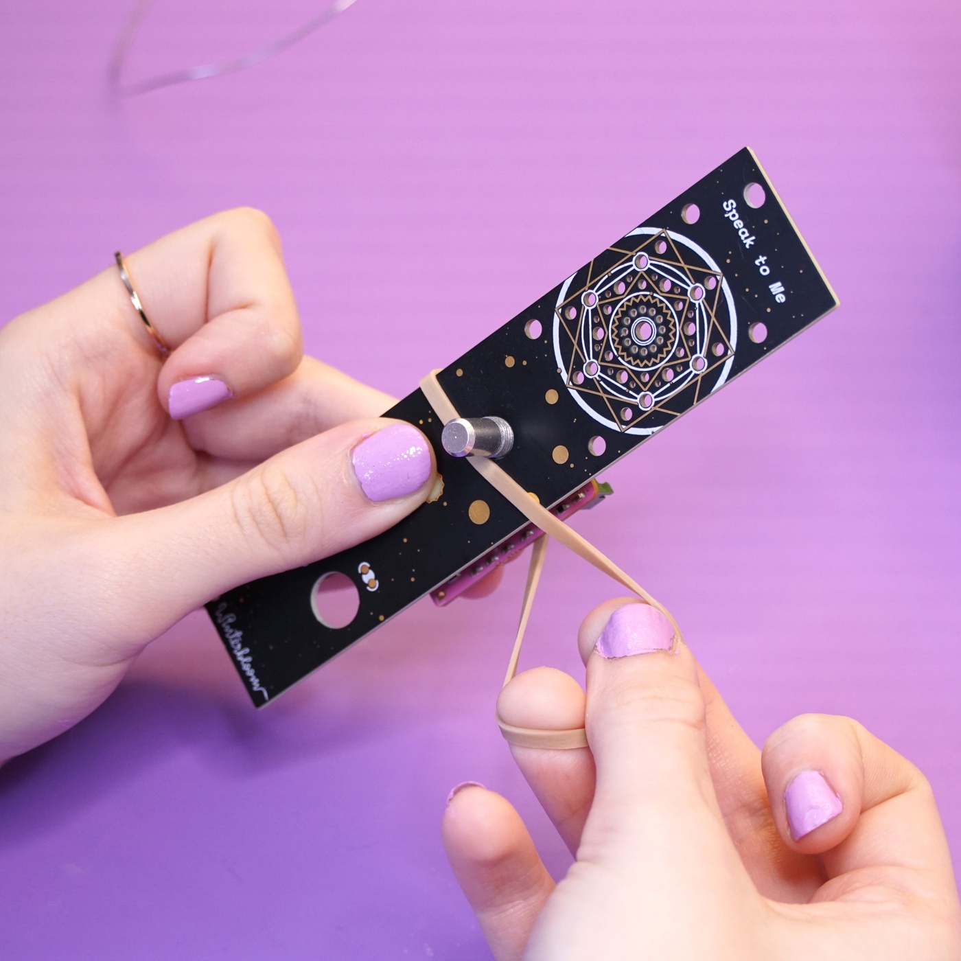 A rubber band being pulled taught across the center of the module