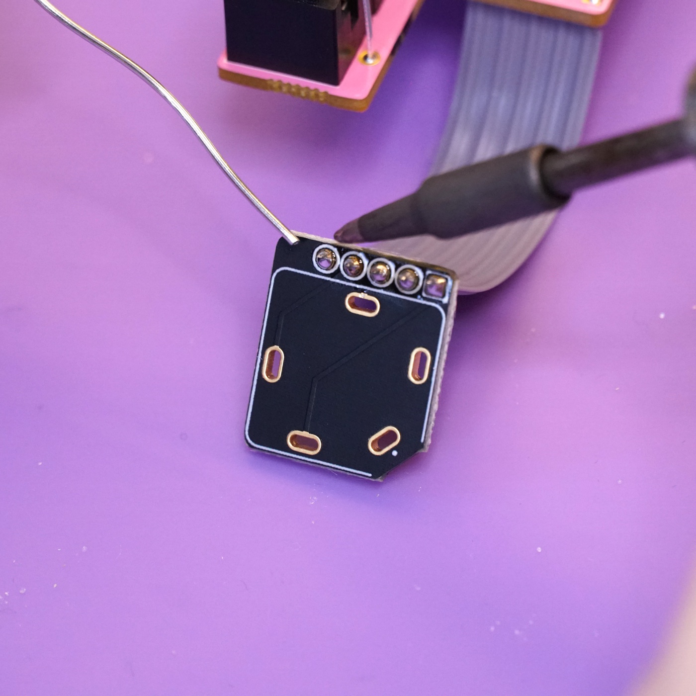 The five conductors of the flat flex cable soldered to the headphone breakout board